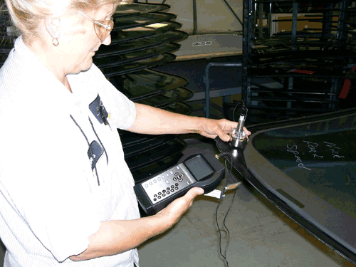 Measurement of adhesive primer thickness on automotive glass using a handheld beta backscatter system.