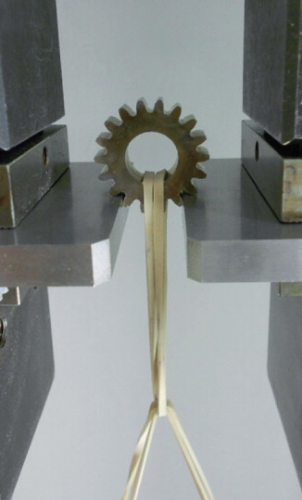 Figure 4. PM gear undergoing pulsating gear-tooth bending fatigue test. (After Andersson)