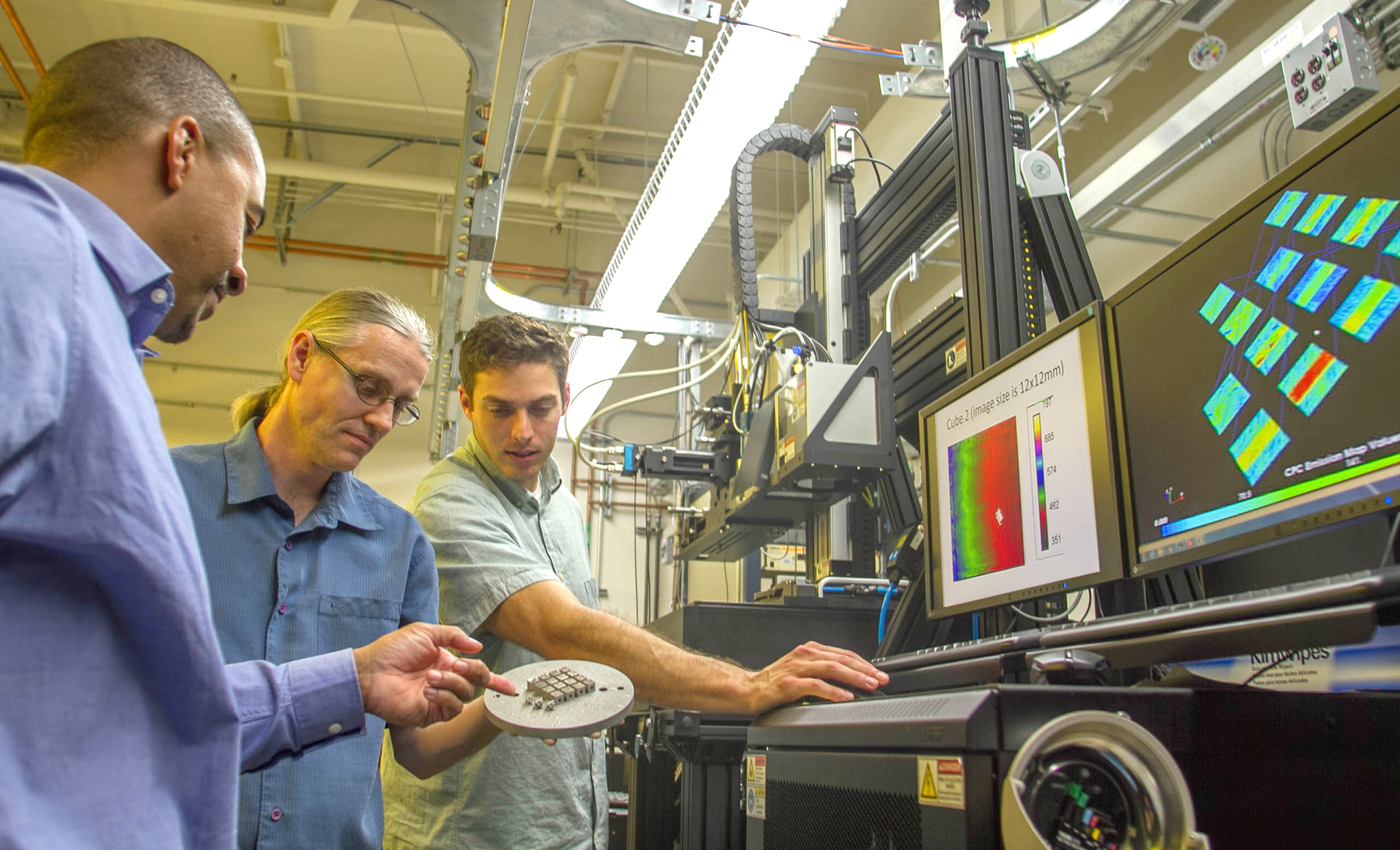 Ibo Matthews, Gabe Guss and Phil Depond examine an additively manufactured (AM) set of metal test cubes using a newly acquired laser-based powder bed fusion R&D platform. Photo courtesy Julie Russell/LLNL .