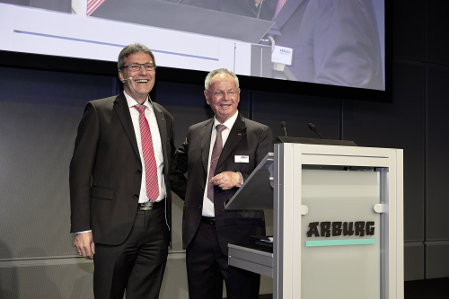 During the farewell celebration, Partner Eugen Hehl presents Herbert Kraibühler with the Arburg logo in gold.