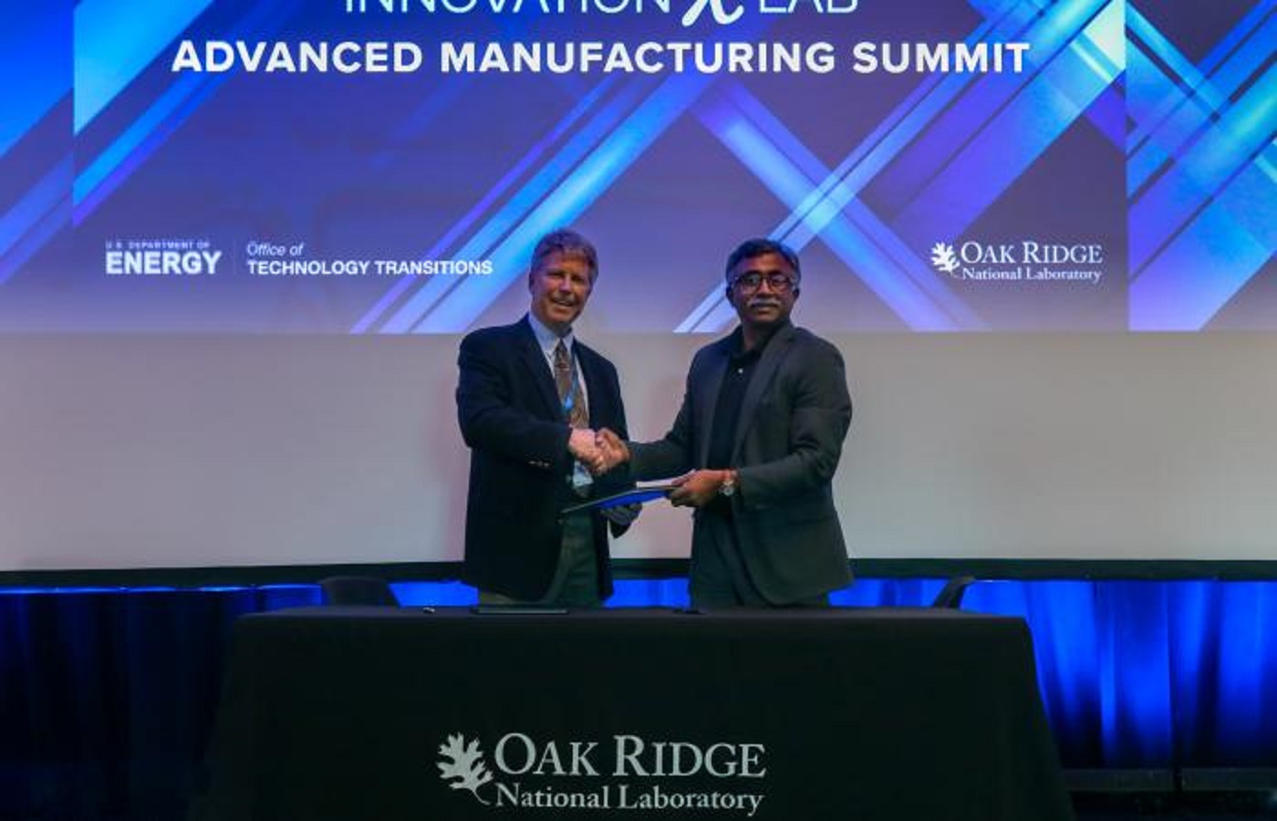 Lincoln Electric’s Tom Matthews (left) and ORNL director Thomas Zacharia signing the agreement during the Department of Energy’s Advanced Manufacturing InnovationXLab Summit. Credit: Genevieve Martin/Oak Ridge National Laboratory, U.S. Dept. of Energy.