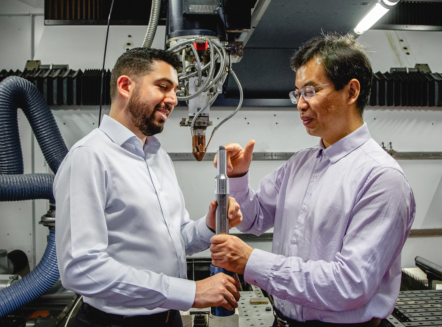 Carmelo Todaro (left) and Ma Qian inspect a 3D printed Titanium alloy cube on the tip of an ultrasound rod.
