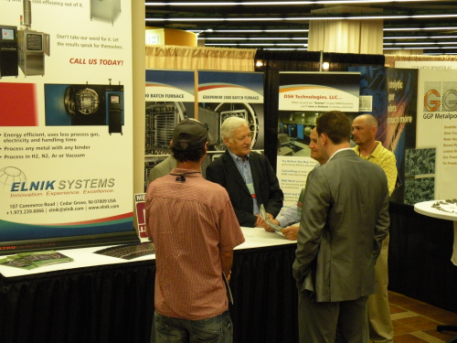 Passers-by stop to visit Claus and Stefan Joens at the Elnik Systems booth.