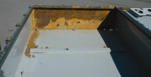 Figure 3: Coating on the internal surface of a delaminated box; the exposed sheet steel is severely corroded.